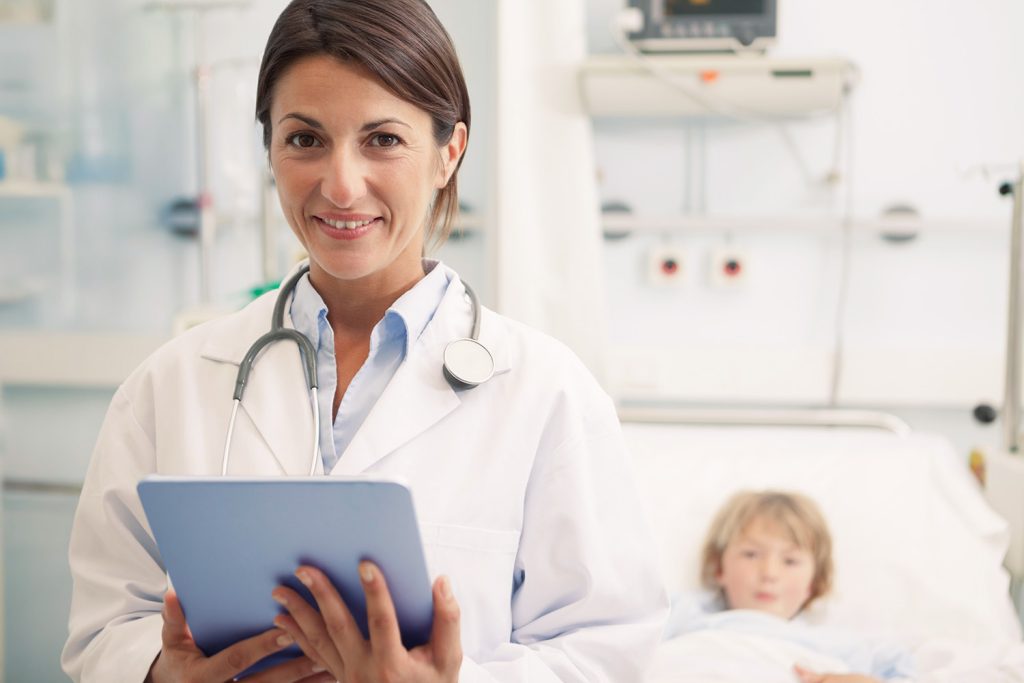 Femme médecin spécialiste en blouse blanche devant un enfant